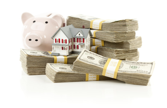 Small House and Piggy Bank with Stacks of Hundred Dollar Bills Isolated on a White Background.